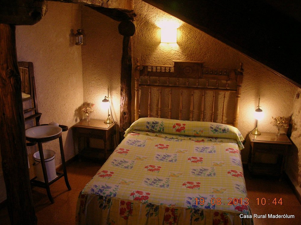 Decoración elegante y cama de matrimonio de la Suite Ayllón en MaderoluM