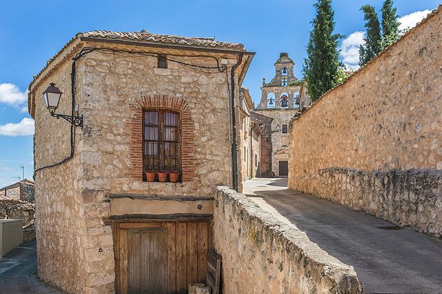Fotografía de la fachada principal y portalada medieval de piedra de la Casa Rural MaderoluM en Maderuelo, Segovia
