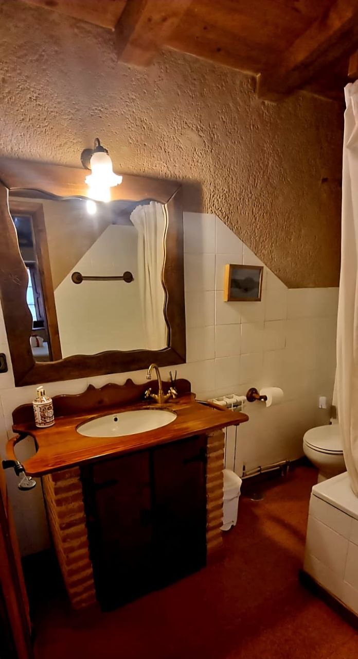 Detalle del lavabo y espejo de diseño del baño de la Suite Maderuelo en MaderoluM