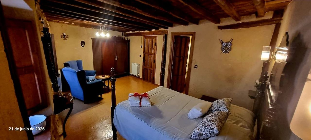 Dormitorio rústico de piedra de la Suite Maderuelo con cama de matrimonio en MaderoluM