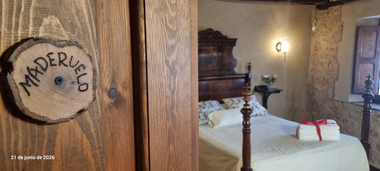 Luminosa habitación de la Suite Maderuelo con paredes rústicas en MaderoluM